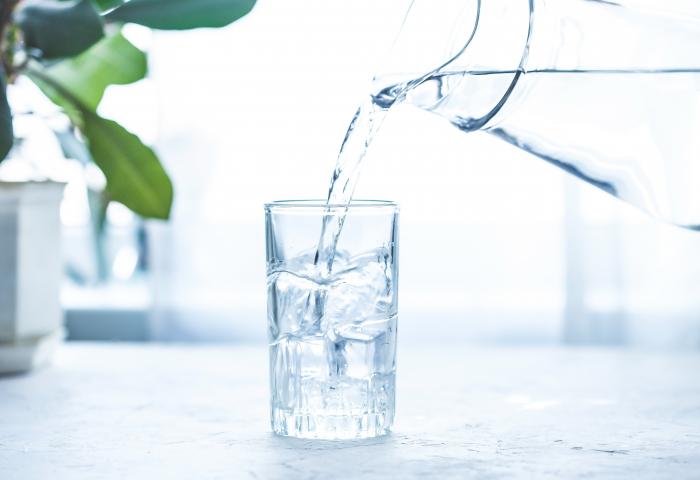 remplissage d'une verre avec une carafe d'eau