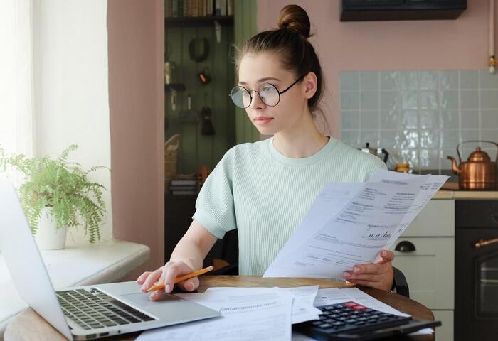 Jeune femme encodant un paiement de facture sur son ordinateur